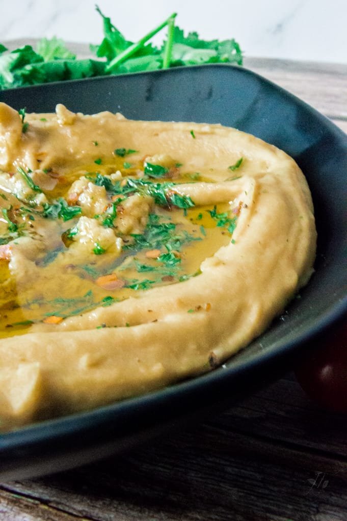 Smooth and creamy Hummus Without Tahini served in a white bowl with a drizzle of olive oil and a sprinkle of paprika.