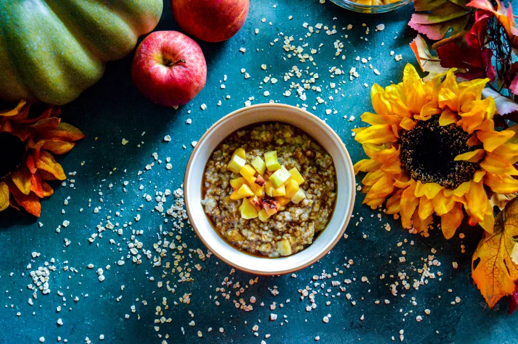 A top-down view of a breakfast spread featuring Maple Fruity Oats with fresh fruit, a jar of maple syrup, and a cup of coffee.