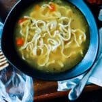 A steaming bowl of homemade chicken noodle soup with tender noodles, rich broth, and fresh herbs.