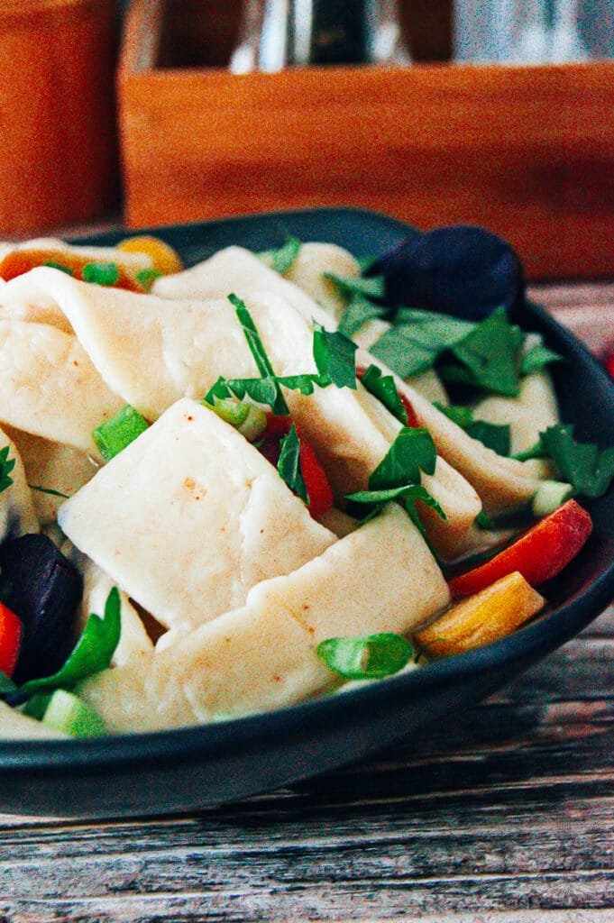 Close-up of cooked egg noodles, tender and ready to be added to soup or served.