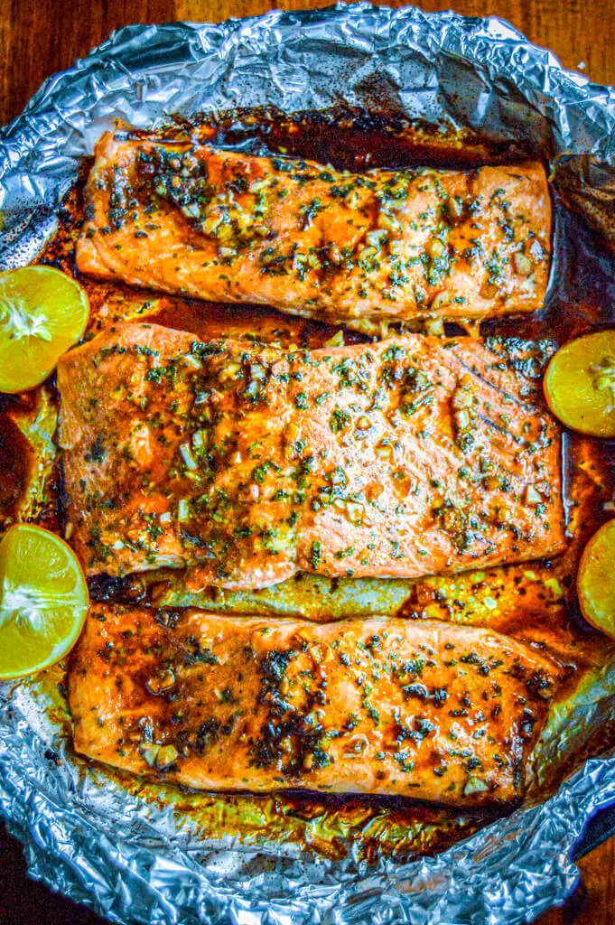 Foil-wrapped Spicy Garlic Salmon fresh out of the oven, glistening with a rich soy and garlic glaze, with steam rising.
